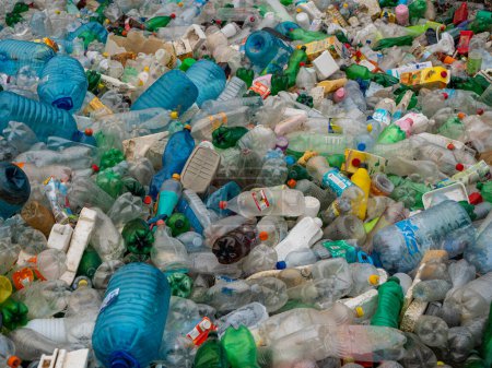 Foto de TIRANA, ALBANIA, MARCH 2022: Top view of pilled up plastic bottles and other waste thrown in nature. Worrying view of littering and environmental damage. Urgent need to raise ecological awareness. - Imagen libre de derechos