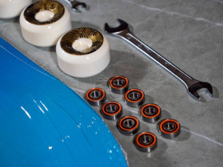 Photo for LA, UNITED STATES, APRIL 2022: CLOSE UP: Lined up set of skateboarding wheels and bearings ready for assembly. Brand new skateboard parts on workshop countertop prepared for mounting on skateboard. - Royalty Free Image