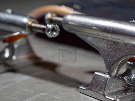 Téléchargez les photos : LA, UNITED STATES, APRIL 2022: CLOSE UP: Brand new pair of skateboard trucks prepared for mounting on skate deck. Polished set of trucks with bushing and kingpins prepared for mounting on new deck. - en image libre de droit
