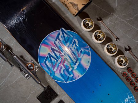 Foto de LA, UNITED STATES, APRIL 2022: TOP DOWN: Brand new packaged skateboard deck with iconic Santa Cruz company logo. Detailed view of bottom graphic on skateboard. New gear almost ready for skateboarding. - Imagen libre de derechos