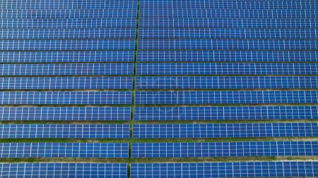Foto de AERIAL: Forrado paneles solares con células solares como parte de la planta de energía solar. Tecnología innovadora de energía solar para la producción de energía alternativa. Uso moderno de la tecnología para un futuro sostenible. - Imagen libre de derechos