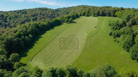 Photo for AERIAL: Farm worker using mechanical tractor mower for mowing the green meadow. Modern agricultural machinery for cultivation of agricultural land. Rural farming scene in the picturesque countryside. - Royalty Free Image