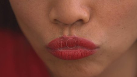 Téléchargez les photos : Detailed view of pursed young female lips after using red lip gloss. Close up view of pretty lady wearing colourful and vibrant cosmetic product for lips. Female person emphasizing her lips. - en image libre de droit
