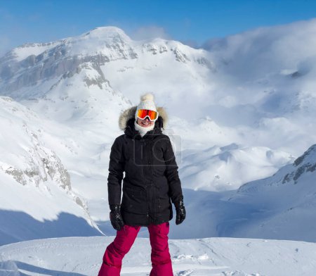 Photo for PORTRAIT: Smiling happy lady on snowy ridge before freeriding fresh powder snow. Female snowboarder with joyful smile and majestic snowy mountain backdrop. Magnificent views in pristine Albanian Alps. - Royalty Free Image