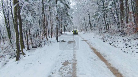 Photo for LJUBLJANA, SLOVENIA - MARCH 2022: Off-road adventure ride with Suzuki Jimny through snow-covered forest. Mini 4-wheel SUV vehicle moving through woodland along snow-covered road on cloudy day. - Royalty Free Image