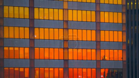 Photo for CLOSE UP: Burnt orange morning sky reflects off the windows of modern skyscrapers in the financial district of New York. Towering corporate building is illuminated by the stunning golden sunset. - Royalty Free Image