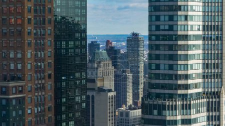 Téléchargez les photos : FERMER : Vue spectaculaire d'en haut sur les gratte-ciel verriers ensoleillés de New York pendant la journée en automne. Vue imprenable sur l'architecture moderne de grande hauteur dans le quartier des affaires de Manhattan Island. - en image libre de droit