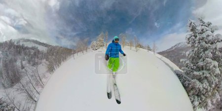 Téléchargez les photos : SELFIE : Le skieur freeride fait un tour dans la fumée froide de l'arrière-pays des montagnes de Deer Valley. Touriste masculin athlétique déchiquète la neige fraîche en poudre couvrant les magnifiques montagnes de l'Utah - en image libre de droit