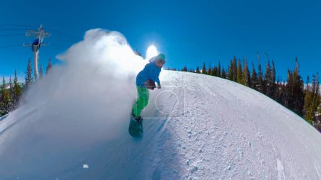 Foto de SELFIE: Snowboarder rocía nieve mientras recorre el sendero prolijamente arreglado en las pintorescas montañas de Colorado. Turista en viaje de snowboard desmenuza la pista de esquí en un día de invierno perfecto. - Imagen libre de derechos