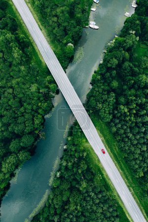 Photo for Aerial view of road over the blue river and green woods in summer Finland - Royalty Free Image