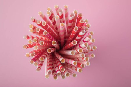 Photo for Drinking straws for Valentine's day. Red, pink and white party paper drinking straws on pink background, top view. - Royalty Free Image