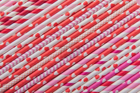 Photo for Drinking straws for Valentine's day. Red, pink and white party paper drinking straws on pink background, top view. - Royalty Free Image