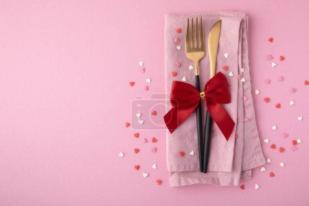 Photo for Valentine's Day background. A set of golden cutlery and pink napkin with hearts confetti on pink background. Top view, copy space. - Royalty Free Image