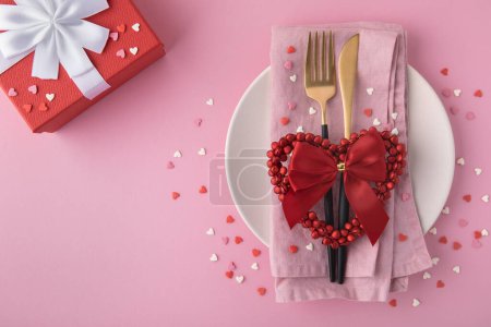 Photo for Valentine's Day background. A set of golden cutlery and pink napkin on plate with hearts confetti on pink background. Top view, copy space. - Royalty Free Image