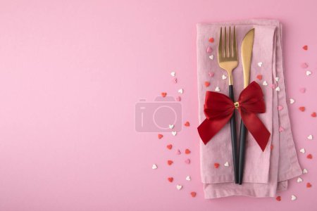 Photo for Valentine's Day background. A set of golden cutlery and pink napkin with hearts confetti on pink background. Top view, copy space. - Royalty Free Image