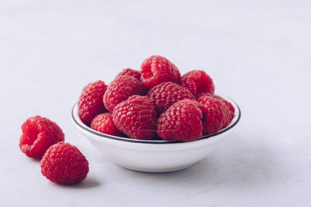 Photo for Raspberry. Fresh organic juicy raspberries in white bowl on gray stone background. - Royalty Free Image
