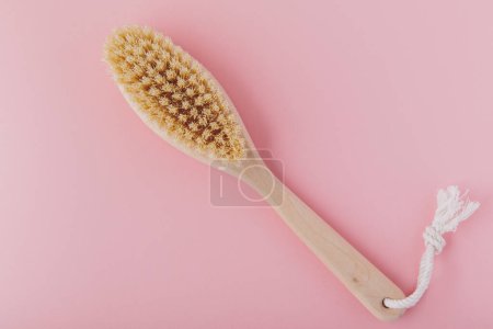 Photo for Massage brush. Natural wooden brush for body massage on pink background. Eco-friendly lifestyle concept and zero waste - Royalty Free Image