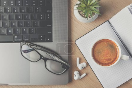 Photo for Home office with modern laptop, glasses, coffee cup - Royalty Free Image