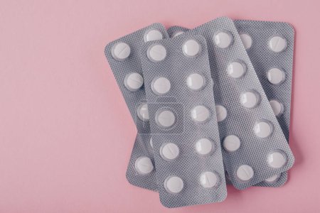 Photo for Pills in blister pack on pink background, top view with copy space. - Royalty Free Image