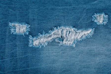 Photo for Jeans. Close-up of blue denim jeans fabric texture background. Ripped jeans - Royalty Free Image