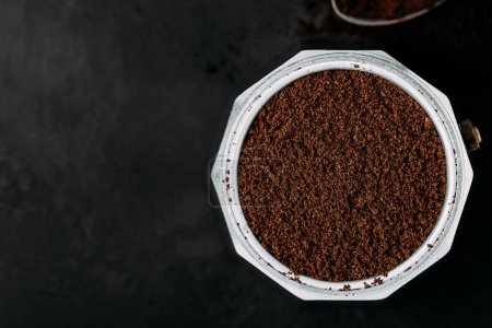 Photo for Ground coffee. Coffee moka pot make, top view with copy space on dark background - Royalty Free Image