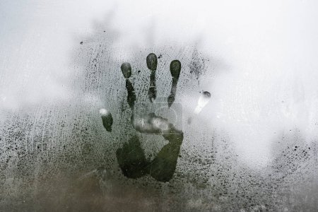 Photo for Window glass with hand print - Royalty Free Image