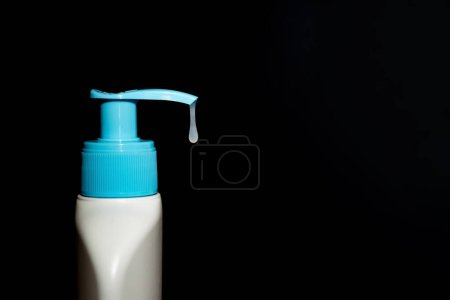 Photo for Cosmetic product, bottle with dispenser, drop. Dark background. - Royalty Free Image
