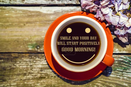 Téléchargez les photos : Tasse orange de café avec texte : "Souriez et votre journée commencera positivement. Bonjour ! ", hortensia sèche sur fond en bois. - en image libre de droit