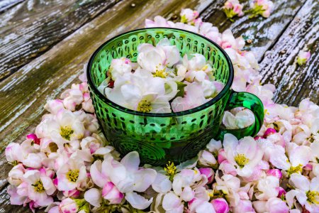 Photo for Heart made of spring flowers and green mug on wooden background - Royalty Free Image