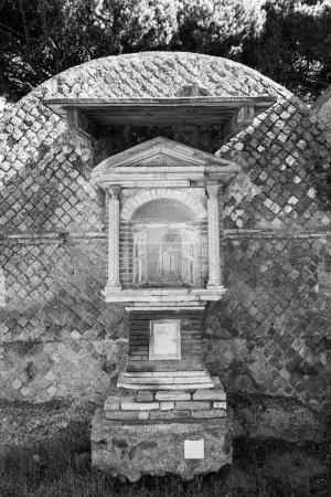Foto en blanco y negro del antiguo altar fuera del edificio de la necrópolis romana en Fiumicino
