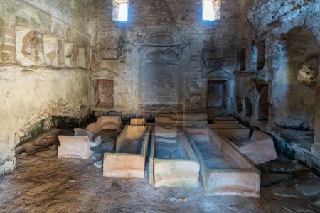 Varios ataúdes vacíos dentro de la antigua charnelhouse en una necrópolis romana en Italia