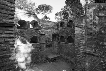 Foto en blanco y negro que muestra las paredes interiores del templo romano en el parque arqueológico en la antigua Ostia