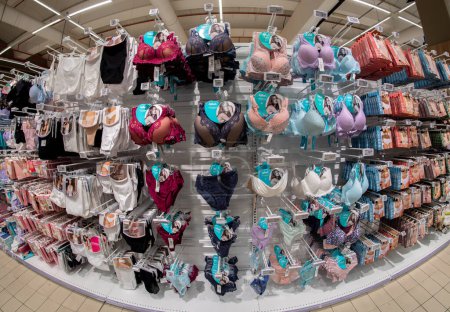 Foto de Cuneo, Italia - 18 de noviembre de 2022: ropa interior femenina, sujetadores y calzoncillos, pantaletas expuestas en estante para la venta en el supermercado italiano, vista del ojo de pez - Imagen libre de derechos