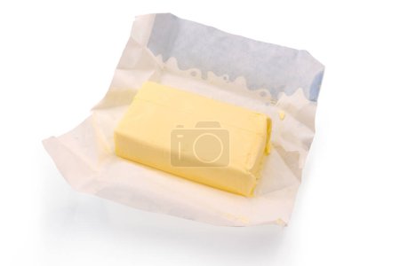 Photo for Unpacked block of butter on wax paper from packaging, isolated on white, clipping path included - Royalty Free Image