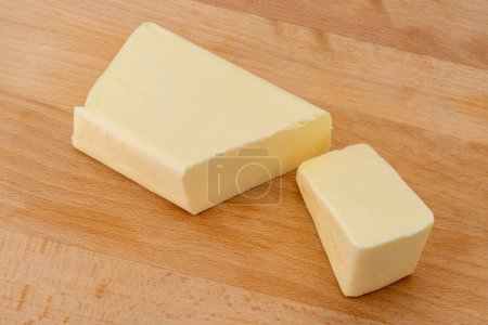 Photo for Block of butter cut on wooden cutting board - Royalty Free Image