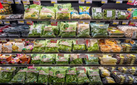 Foto de Italia - 31 de mayo de 2023: Ensalada y verduras limpias listas para comer en bolsas transparentes y varios paquetes en los estantes de los supermercados italianos - Imagen libre de derechos