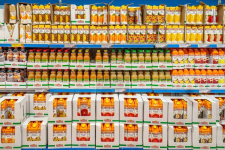 Foto de Italia - 02 de agosto de 2023: zumos de frutas en botellas de plástico y en cajas de cartón expuestas en estantes para la venta en una tienda italiana de supermercados de descuento - Imagen libre de derechos