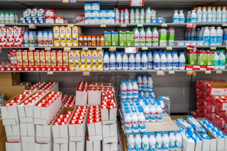 Foto de Italia - 08 de agosto de 2023: leche envasada en botellas y cajas de plástico envases de alimentos de varios tipos y marcas dispuestas en estantes para la venta en la tienda italiana de supermercados de descuento - Imagen libre de derechos