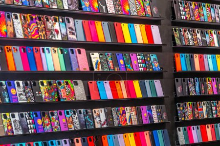 Italy - August 20, 2023: Coloured smartphone covers displayed on shelf for sale in phone shops