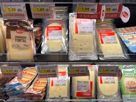 Foto de Italia - 28 de diciembre de 2023: Queso en rodajas de varios tipos envasado en bolsas de plástico envasadas al vacío de varias marcas que se muestran en el estante refrigerado para la venta en el supermercado italiano - Imagen libre de derechos