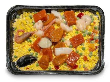 Paella mit Reis und vorgekochten Zutaten vakuumverpackt und tiefgefroren in der Schale, isoliert auf weiß mit Clip-Pfad enthalten 