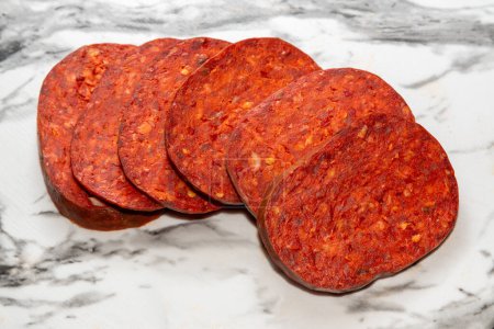 Nduja of pork and Calabrian chili pepper, slices of sausage spicy on white marble top. Clipping path included