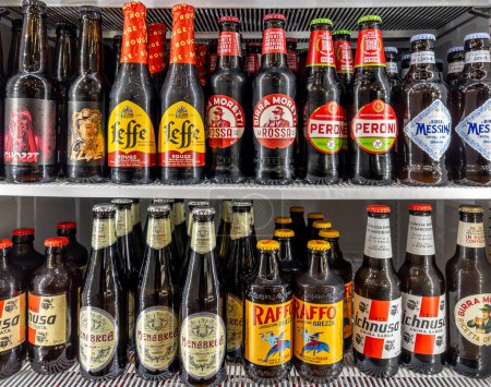 Photo for Italy - april 04, 2024: Beer in glass bottles of various types and brands in refrigerated counter. Italian, Sicilian and Sardinian beers and Leffe beer displayed for sale in cold weather - Royalty Free Image