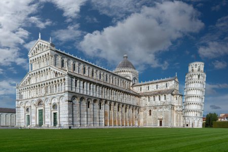 Pisa, Italien - 05. April 2024: Landschaft der Piazza dei Miracoli mit der Kathedrale von Pisa und dem Schiefen Turm unter blauem Himmel mit weißen Wolken