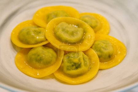 Round ravioli with butter sauce, round tortelli filled with vegetables and cheese