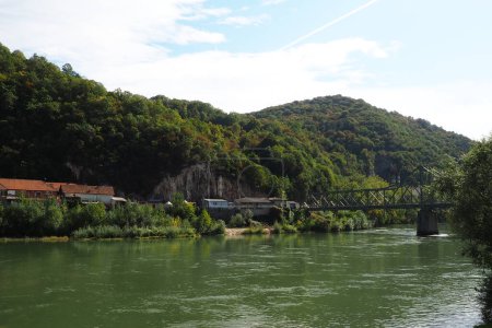 Foto de Mali Zvornik, Serbia, 29 de septiembre de 2022. Río Drina cerca de Banja Koviljaca, vista de la costa de Serbia desde BiH. El flujo de agua, vegetación en la orilla opuesta del río. Casas residenciales - Imagen libre de derechos