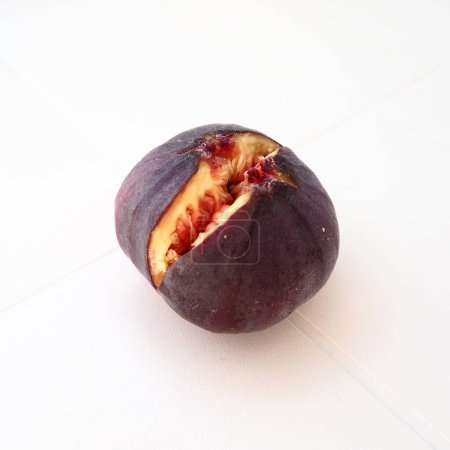 Photo for Fig or fig tree, or common fig tree, or Ficus carica is a subtropical deciduous plant of the genus Ficus of the Mulberry family. Ripe purple fig fruits on a light background. Healthy food. - Royalty Free Image