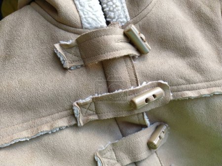 Photo for Suede outerwear. Overhead loops for buttons. Hidden zipper. Beige faux suede with sheepskin on the fold of a demi-season garment. seams in the material. Clothing industry and fashion - Royalty Free Image