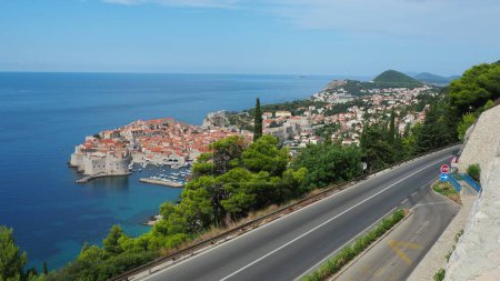 Foto de Tráfico por carretera cerca del casco antiguo de Dubrovnik en Croacia. Dubrovnik Ragusa es una ciudad en Croacia, el centro administrativo del condado de Dubrovnik-Neretva. Vista superior desde la plataforma de observación en la roca - Imagen libre de derechos