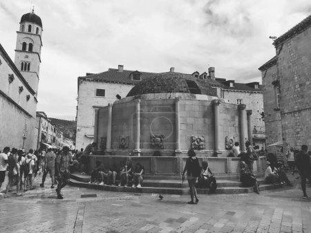 Foto de Big Onofrio Fountain, Velika Onofrijeva chesma, Dubrovnik, Croacia. Suministro de agua establecido durante el período de Quattrocento. Numerosos turistas multinacionales felices caminan por el Stradun 14 agosto 2022. - Imagen libre de derechos